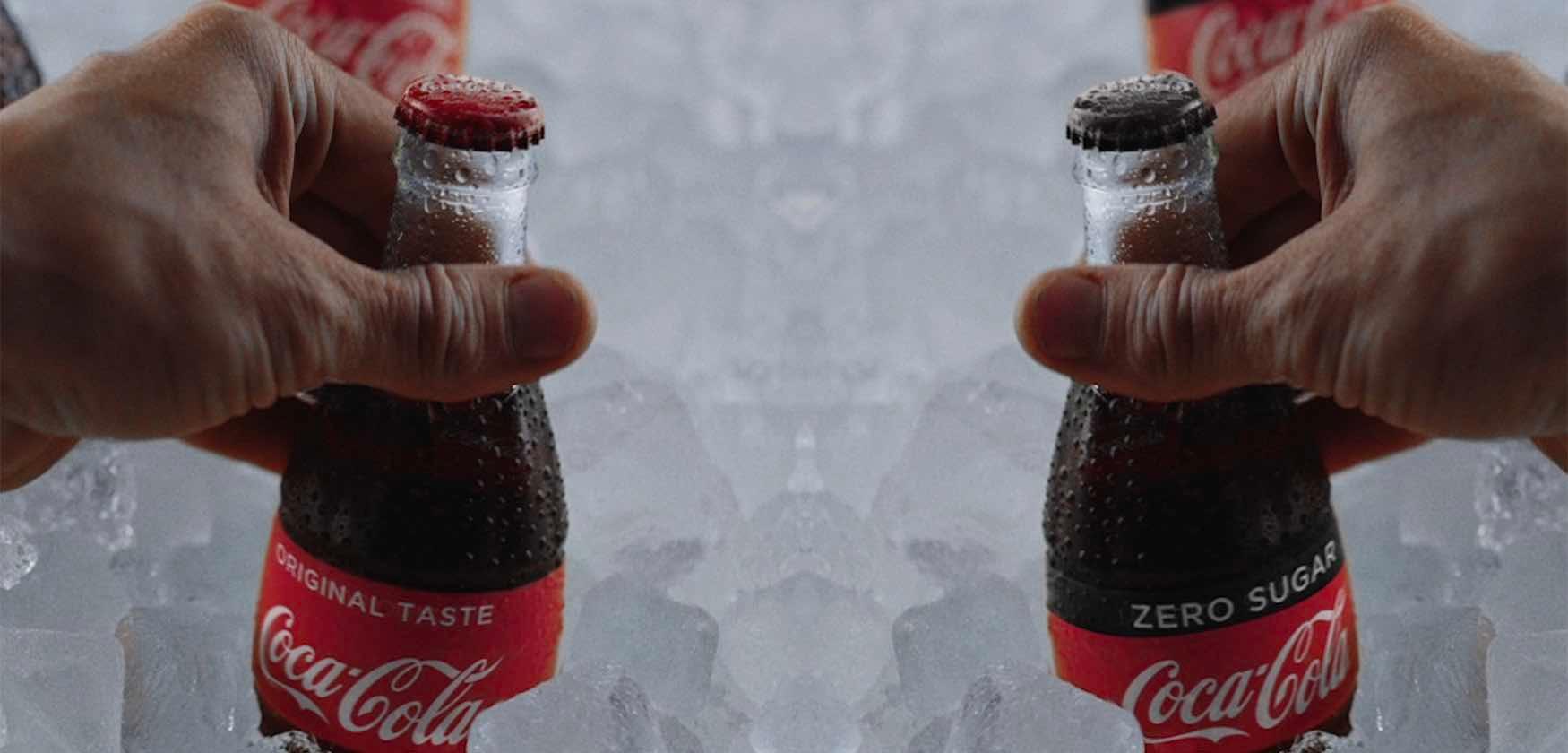 Two Coca-Cola Bottles on Ice