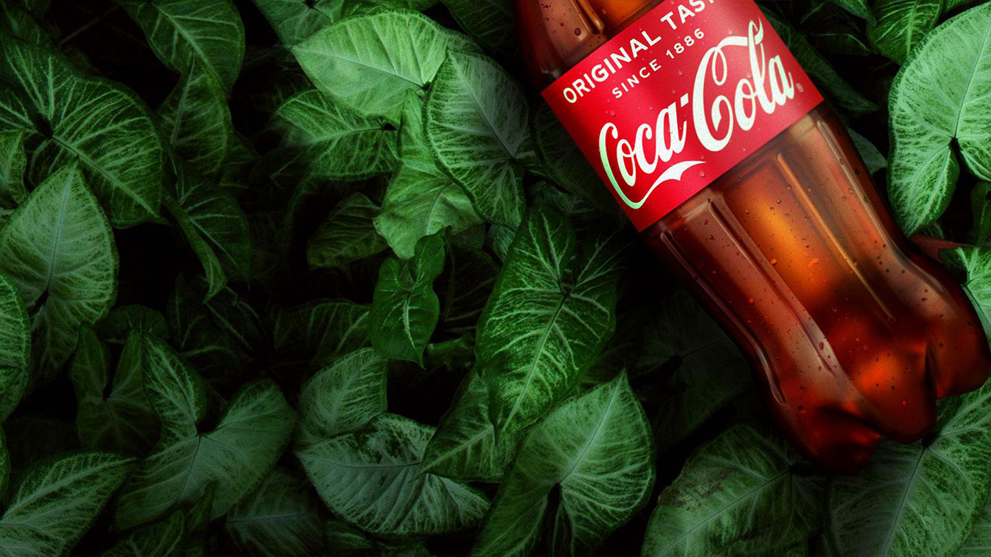 A Coca-Cola bottle on top of various plants