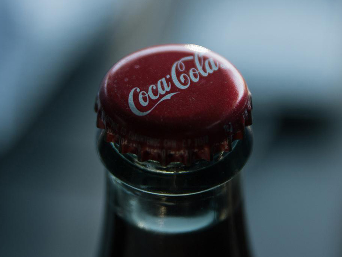 Detail of the lid of a glass bottle of Coca-Cola with a blurry background