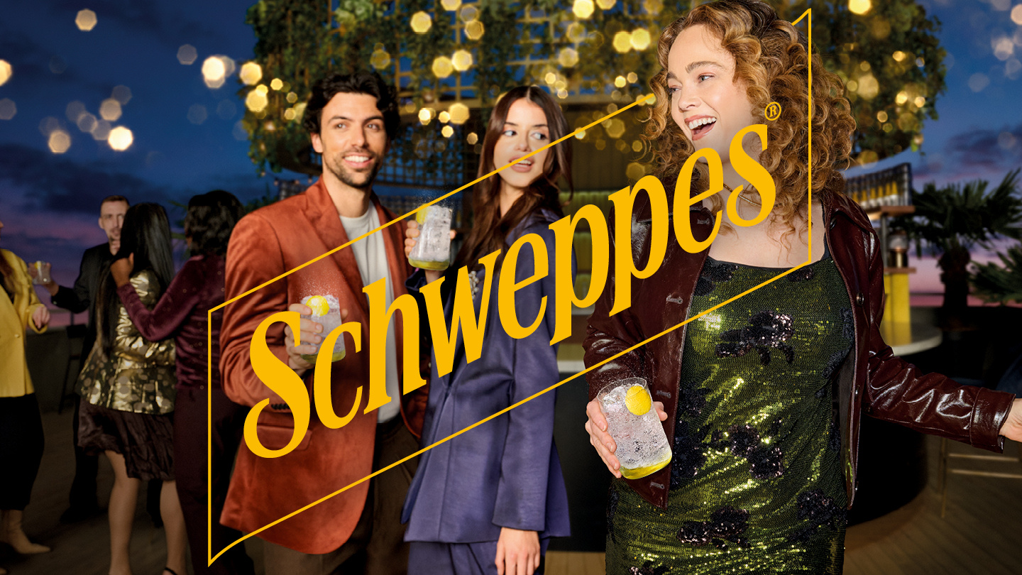 people outside holding a glass and schweppes logo