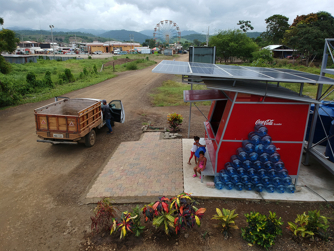 Coca-Cola stand in a local community with a ferris wheel & buildings in the background