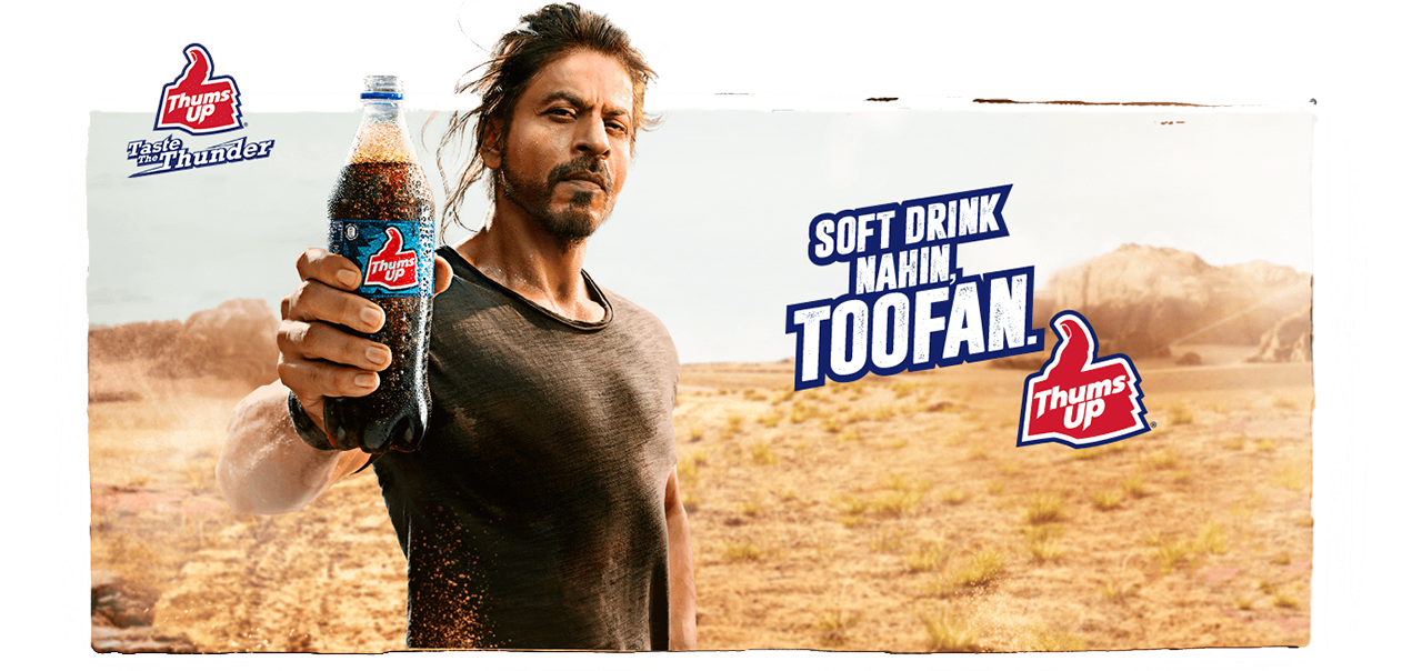 Man holding a bottle of Thums up with text reading: Soft drink makin Toofan