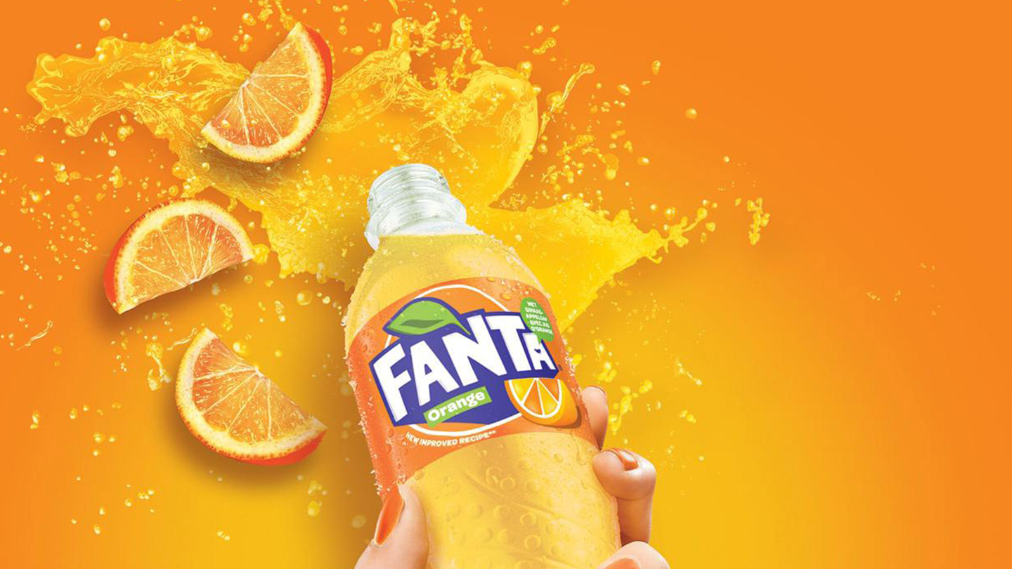 Fanta drykkur með appelsínur skvettum á bakgrunn