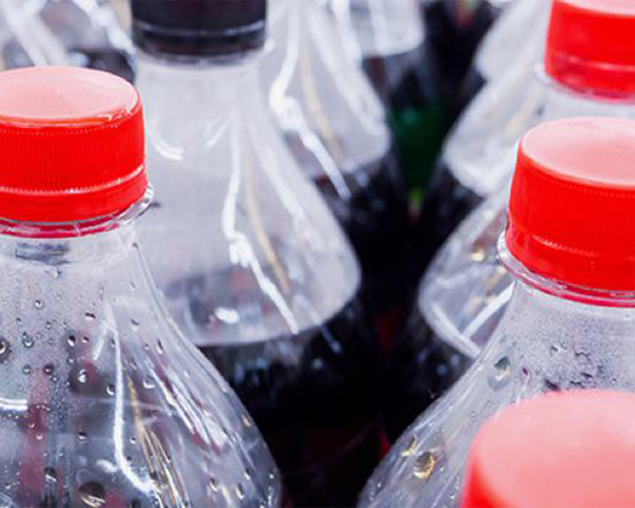 Colli di bottiglie di Coca-Cola in plastica.