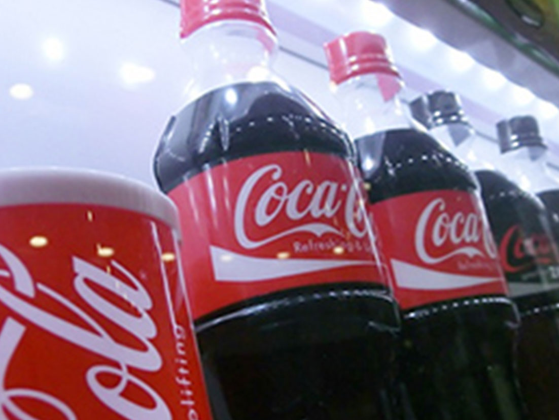 LED点灯自販機に並ぶコカ・コーラ缶とボトル