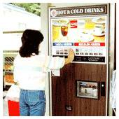 ヴィンテージな自動販売機からコカ・コーラの飲み物を購入する女性