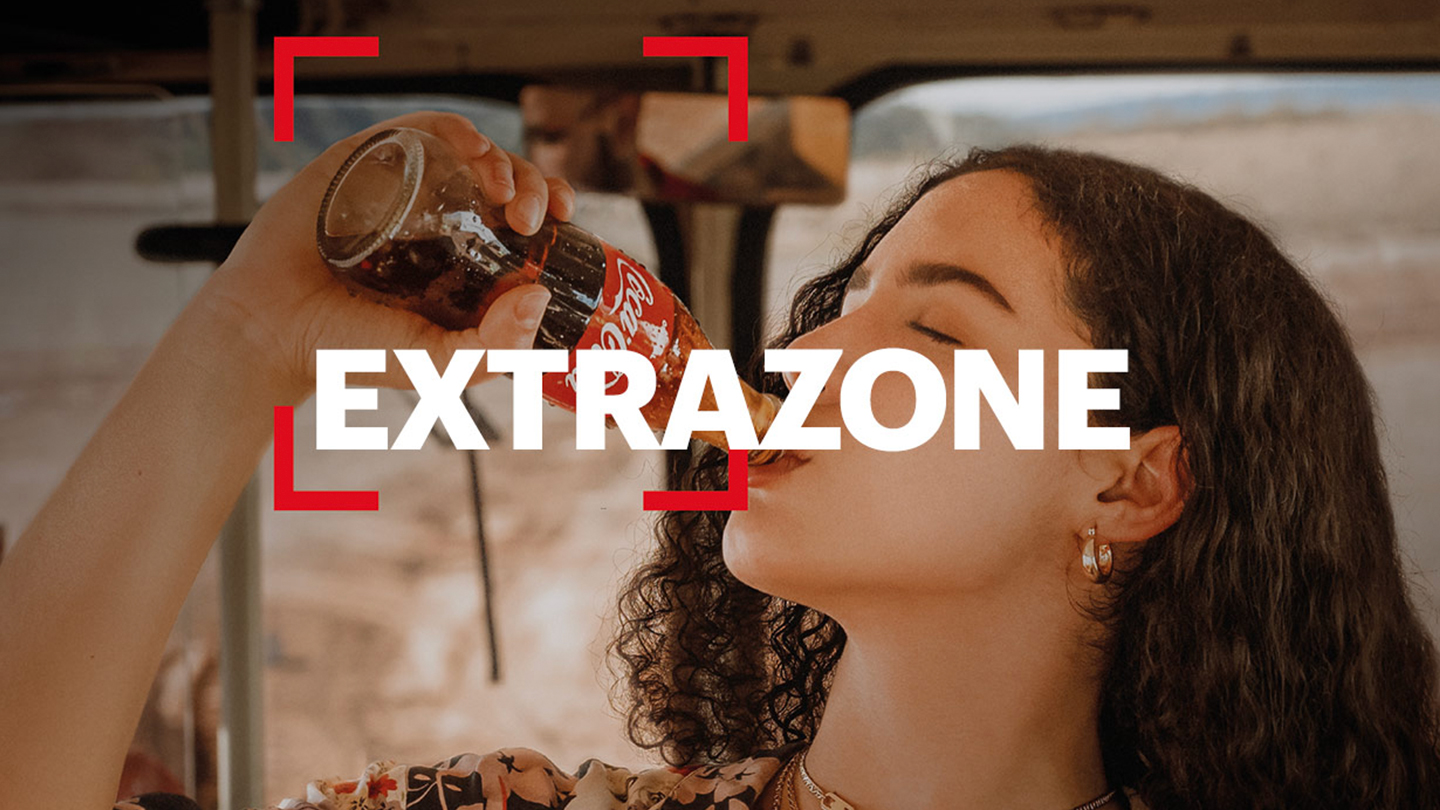 Coca-Cola Extrazone баракчасында Coca-Cola алкоголсуз газдалган суусундугун ичип жаткан аял көрсөтүлгөн.