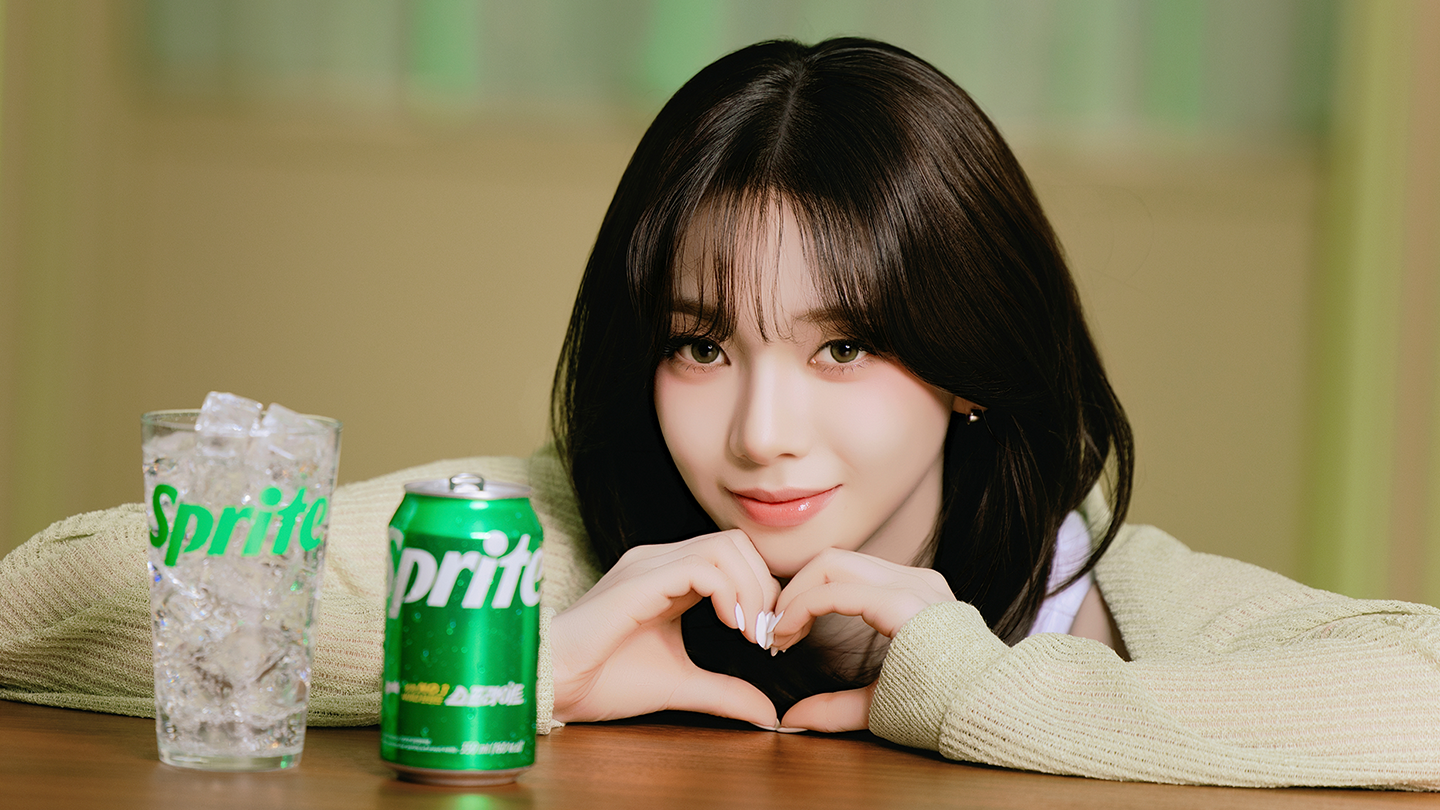 카리나가 스프라이트 옆에서 하트 손모양을 하고 있는 사진