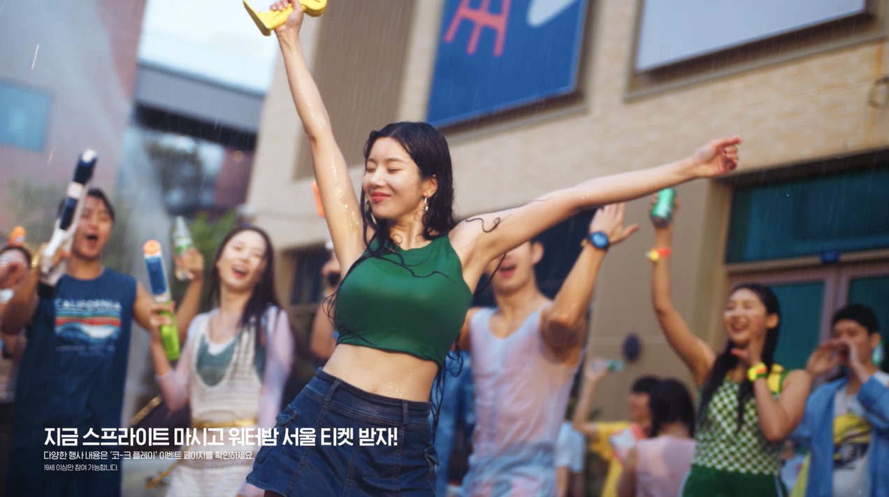 물총을 든 군중들에 둘러싸인 권은비가 스프라이트 샤워를 즐기면서 환호를 받고 있다. “지금 스프라이트 마시고 워터밤 서울 티켓 받자!” 카피 문구가 아래 적혀 있다.