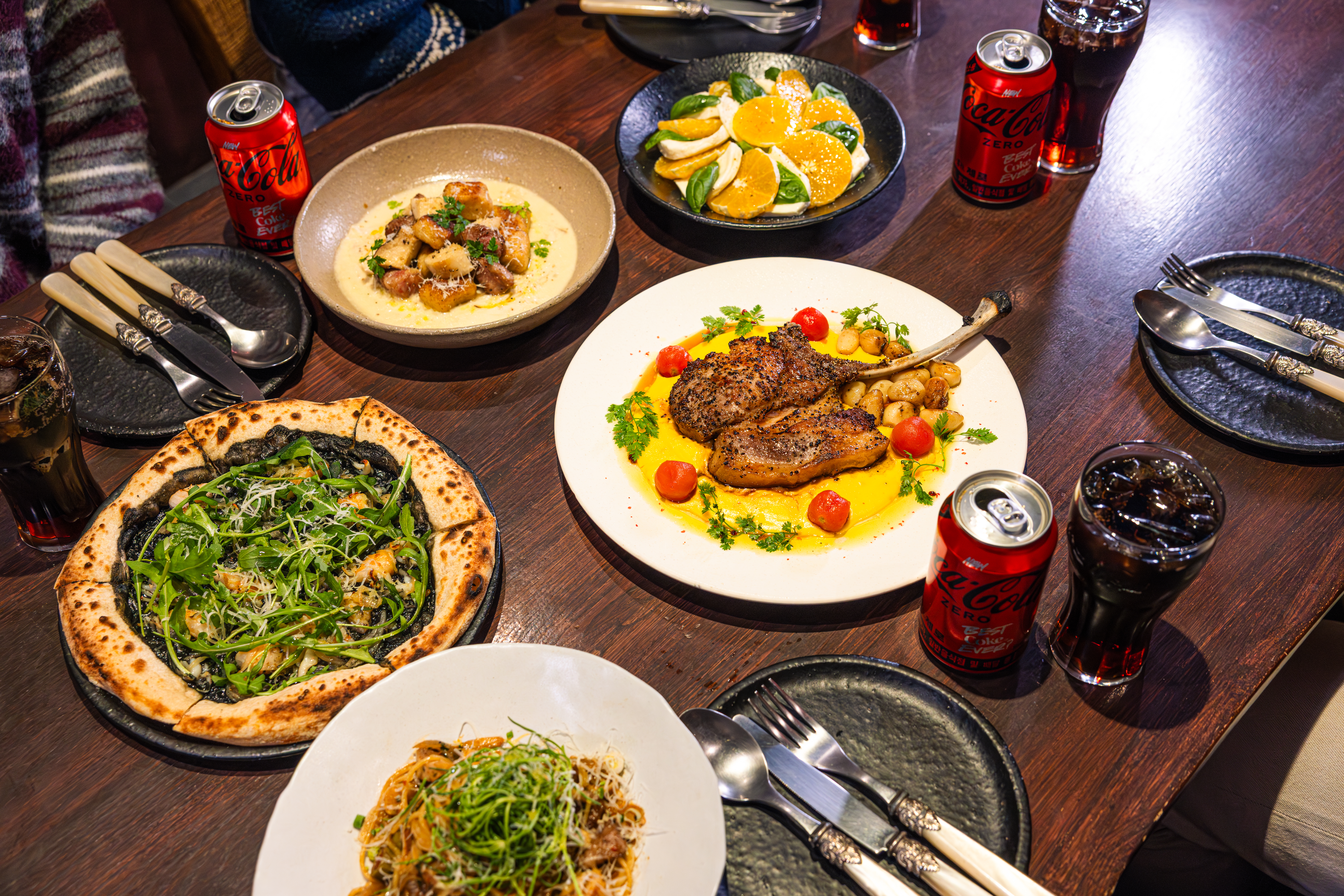 '소랑호젠'의 대표메뉴, 제주 흑돼지 프렌치렉 스테이크, 제주 멜젓, 그리고 제주 거멍을 코카-콜라 제로와 함께 즐기고 있다.