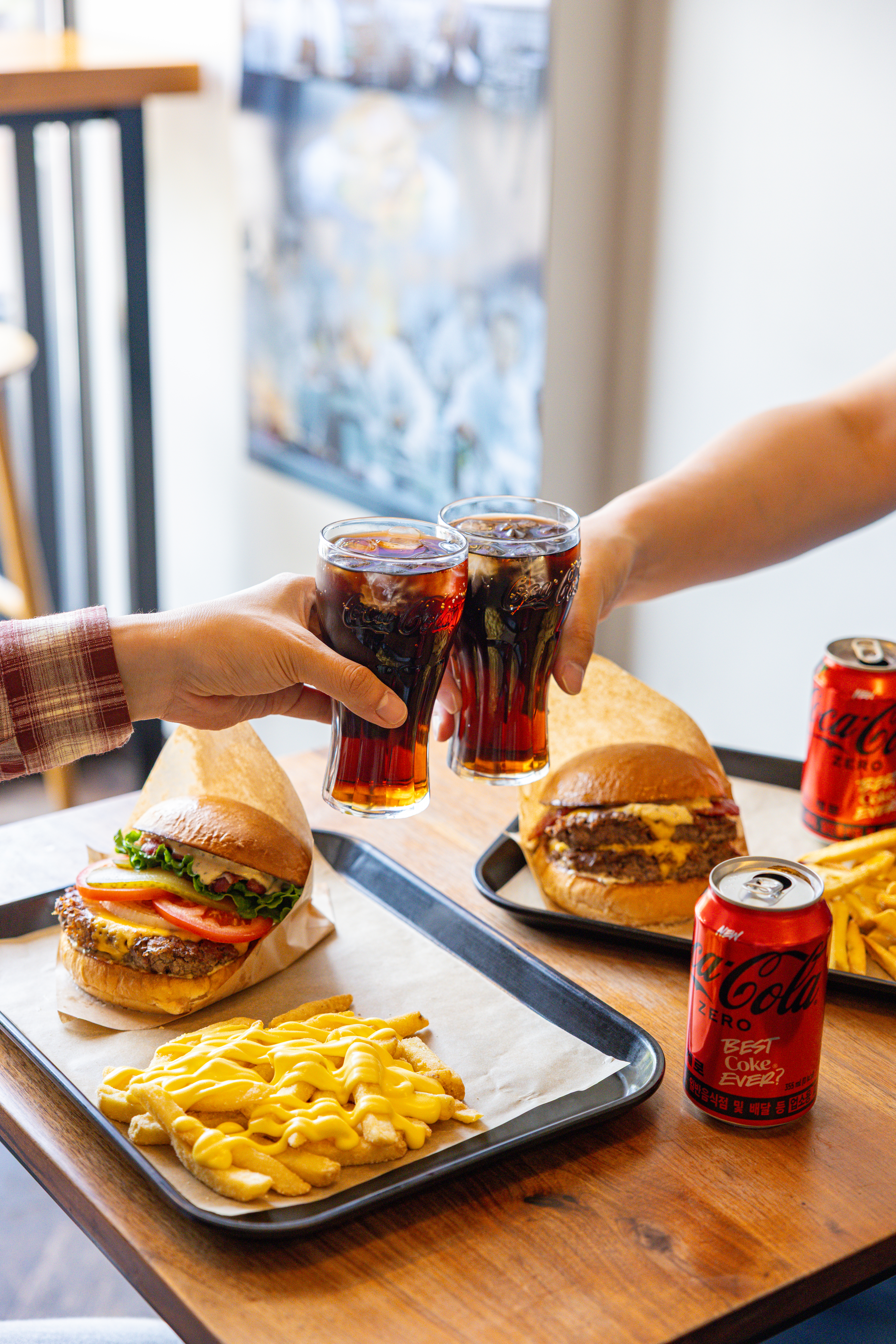 레드리본 맛집 ’래빗홀버거컴퍼니’의 대표메뉴, 클래식 버거 세트와 더더블버거 세트를 코카-콜라 제로와 함께 즐기고 있다.