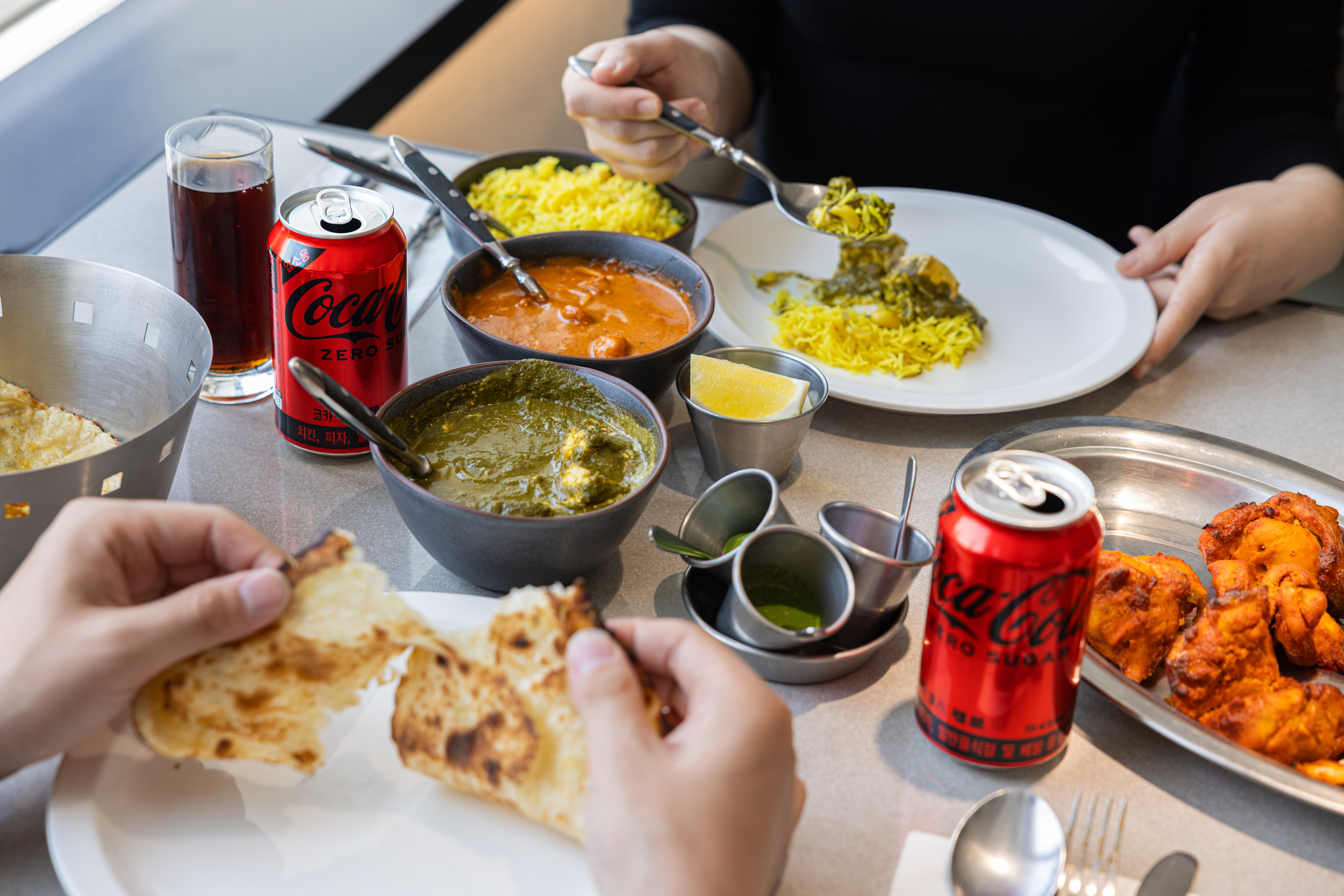 명동 레드리본 맛집, 타지의 대표메뉴, 프로운 마카니, 빨락 파니르, 로건 조쉬를 코카-콜라 제로와 함께 즐기고 있는 사진