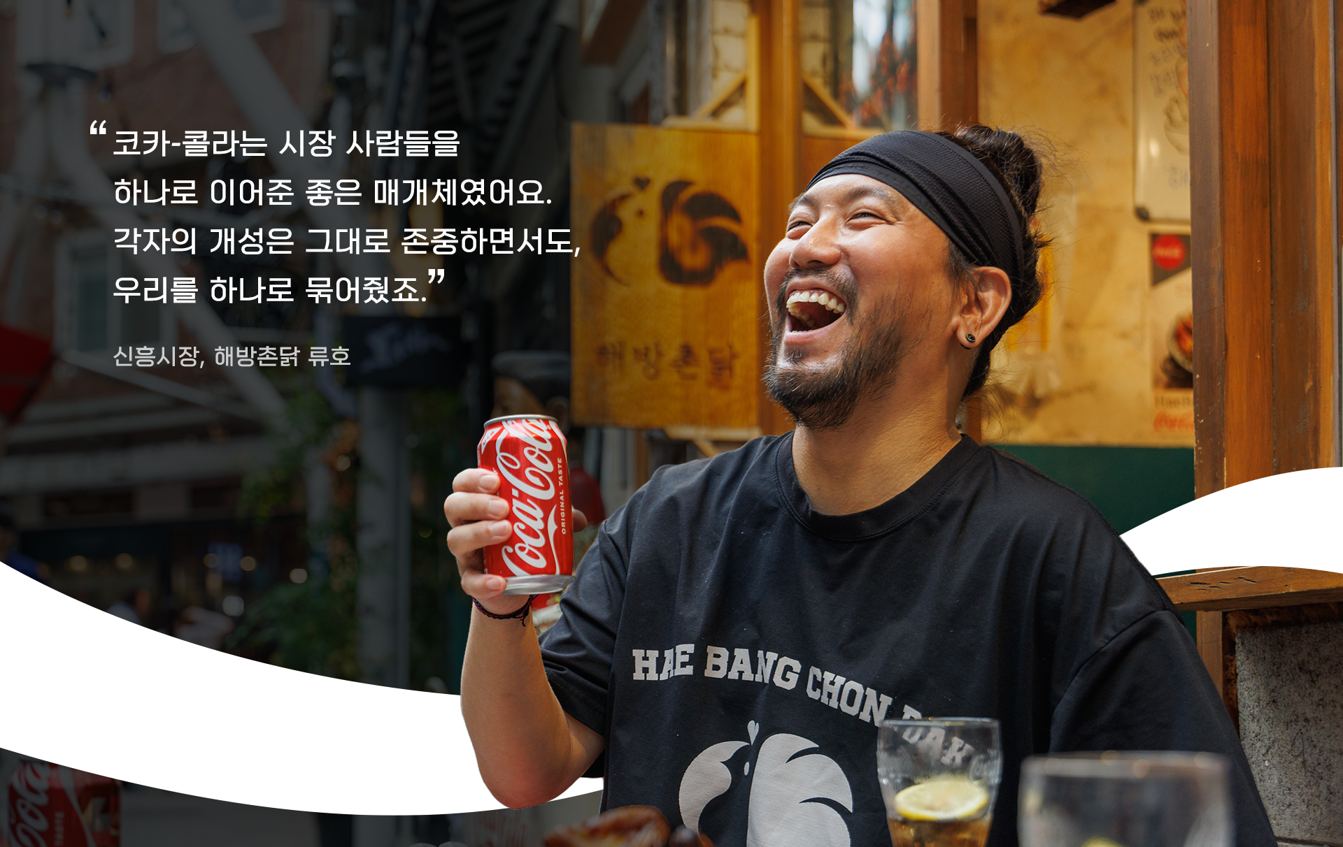 신흥시장에 위치한 전기구이 통닭집, 해방촌닭의 야외 좌석에서 코카-콜라를 마시며 웃고 있는 류호 사장의 모습 