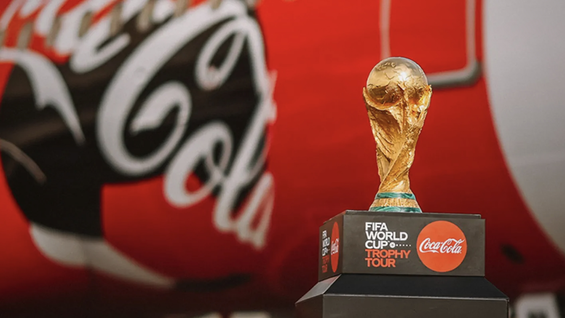 코카-콜라 전세기를 배경으로 FIFA  월드컵 오리지널 트로피가 놓여있는 모습