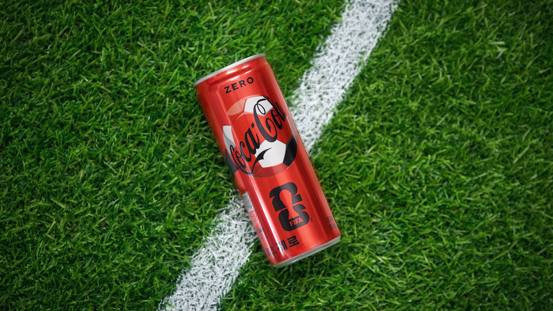 축구장 잔디 위에 놓여있는 코카-콜라 제로 26 FIFA 월드컵 스페셜 패키지 