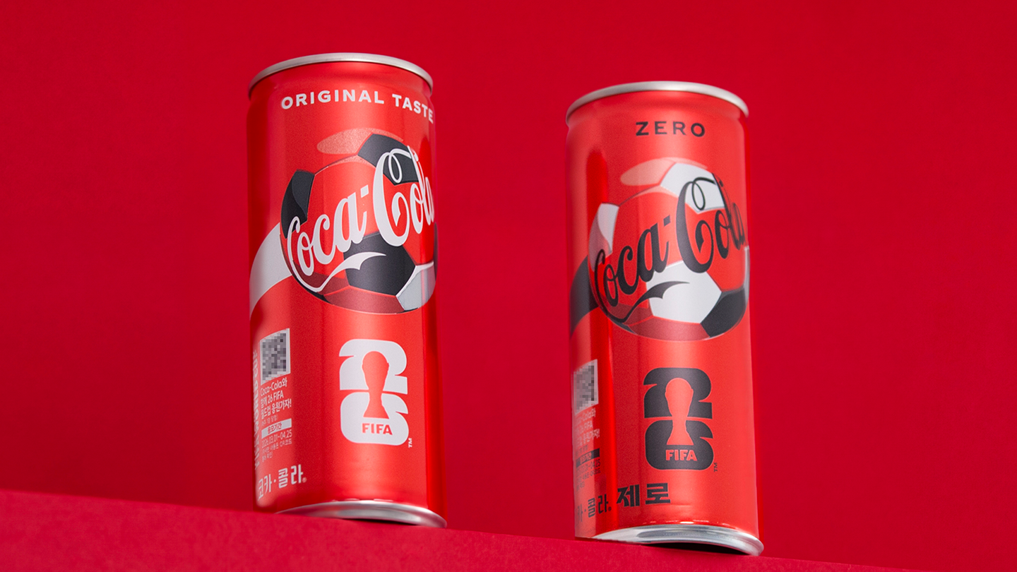 26 FIFA 월드컵 스페셜 패키지로 제작된 코카-콜라 오리지널과 코카-콜라 제로 2종이 놓여있다. QR 코드를 스캔하면 26 FIFA 월드컵 원정 응원 여행 패키지에 응모할 수 있다.