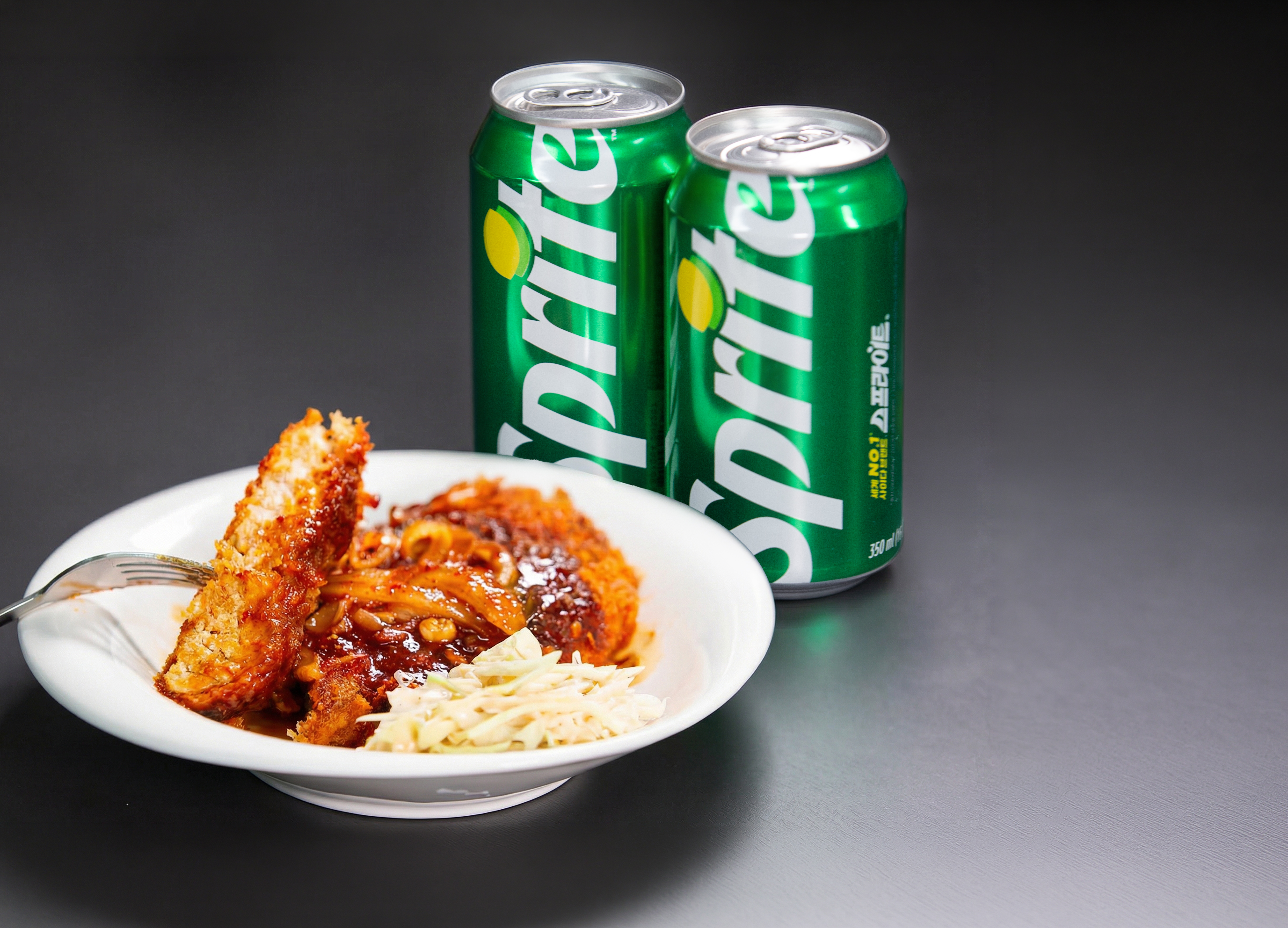 매운 돈까스를 스프라이트와 함께 즐기고 있는 이미지.