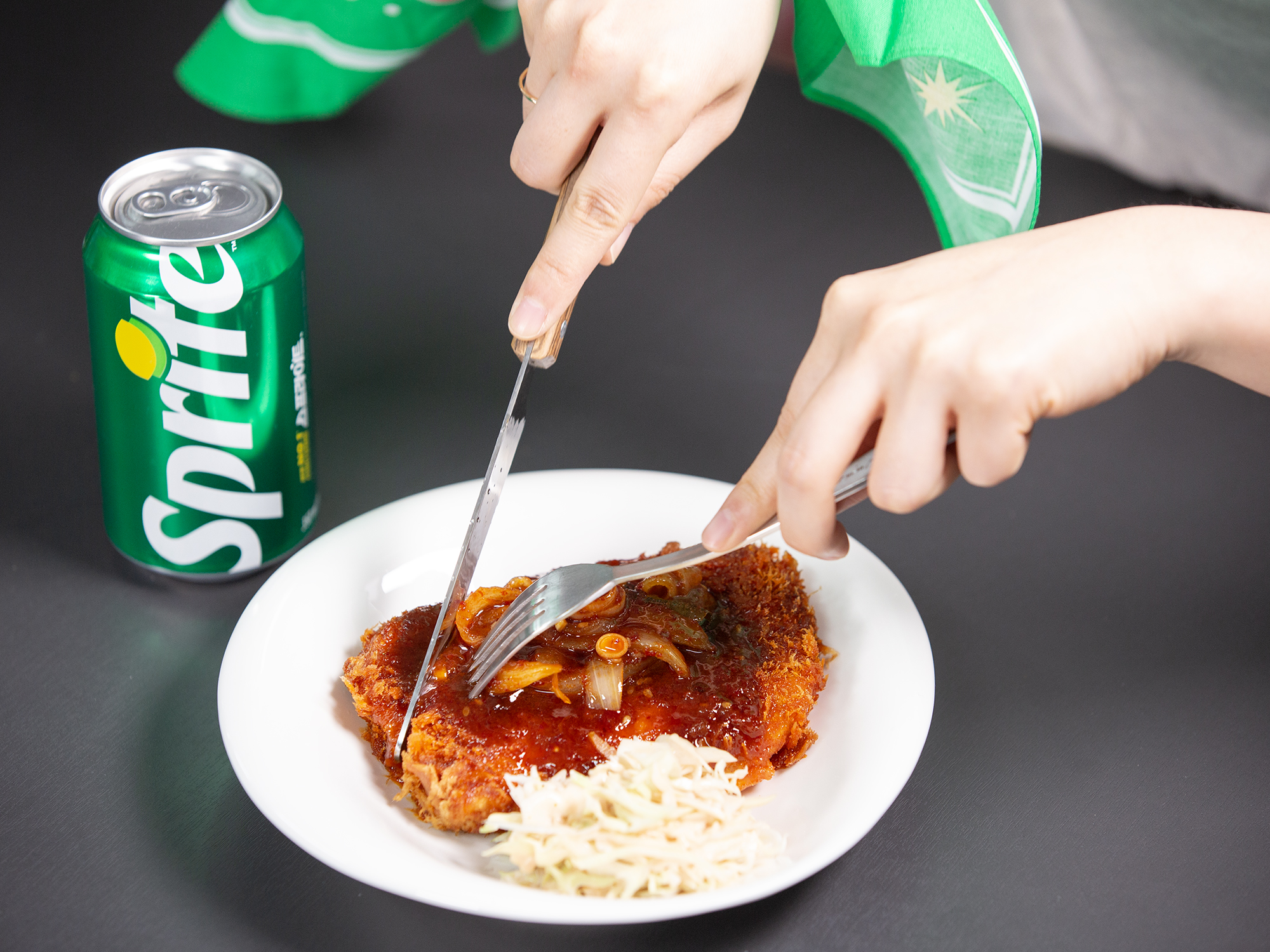 매운 돈까스를 스프라이트와 함께 즐기고 있는 이미지.