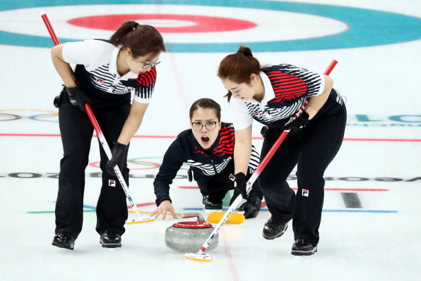 GANGNEUNG, SOUTH KOREA - FEBRUARY 16: EunJung Kim of Republic of Korea delivers a stone between YeongMi Kim and SeonYeong Kim during their game against Switzerland in the Curling Women's Round Robin Session 4 at Gangneung Curling Centre on February 16, 2018 in Gangneung, South Korea.(Photo by Maddie Meyer/Getty Images)
