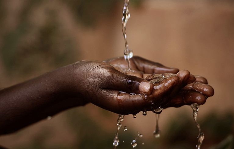 A pair of hands cupped with water flowing into them