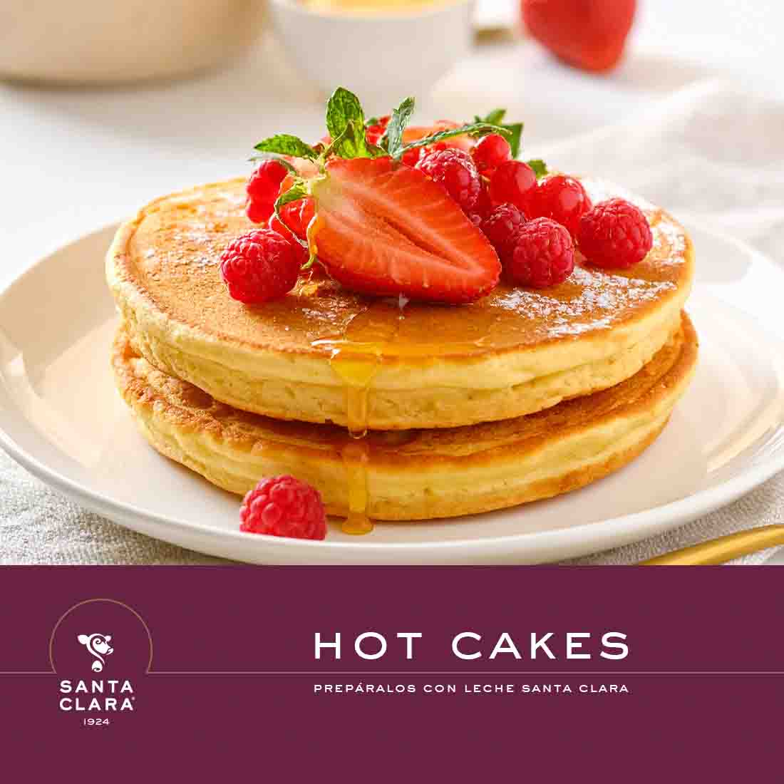  Una imagen de hot cakes con fresas y frambuesas encima, con el logo de Santa Clara y el texto "HOT CAKES PREPÁRALOS CON LECHE SANTA CLARA".