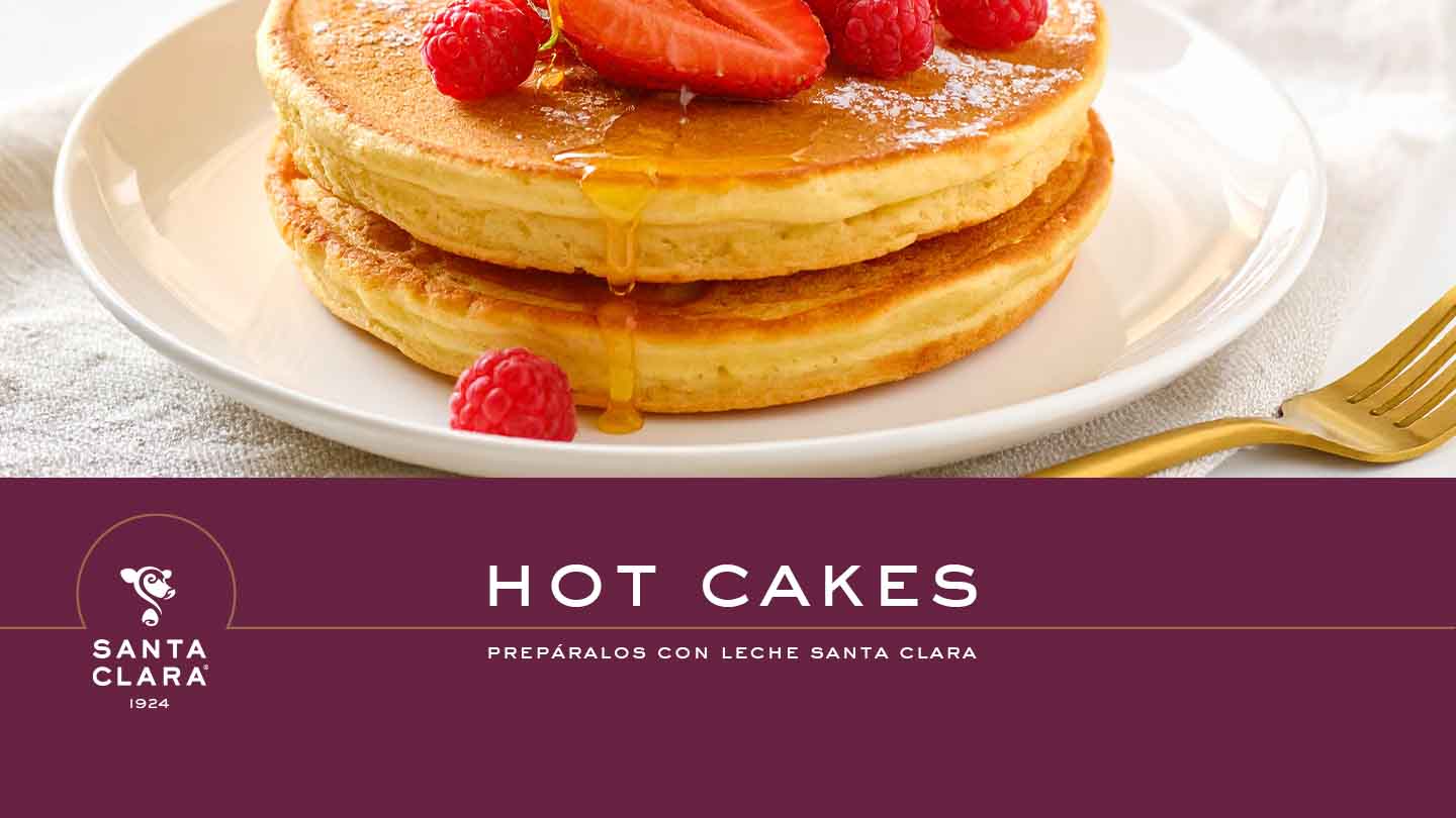 Una imagen de hot cakes con fresas y frambuesas encima, con el logo de Santa Clara y el texto "HOT CAKES PREPÁRALOS CON LECHE SANTA CLARA".