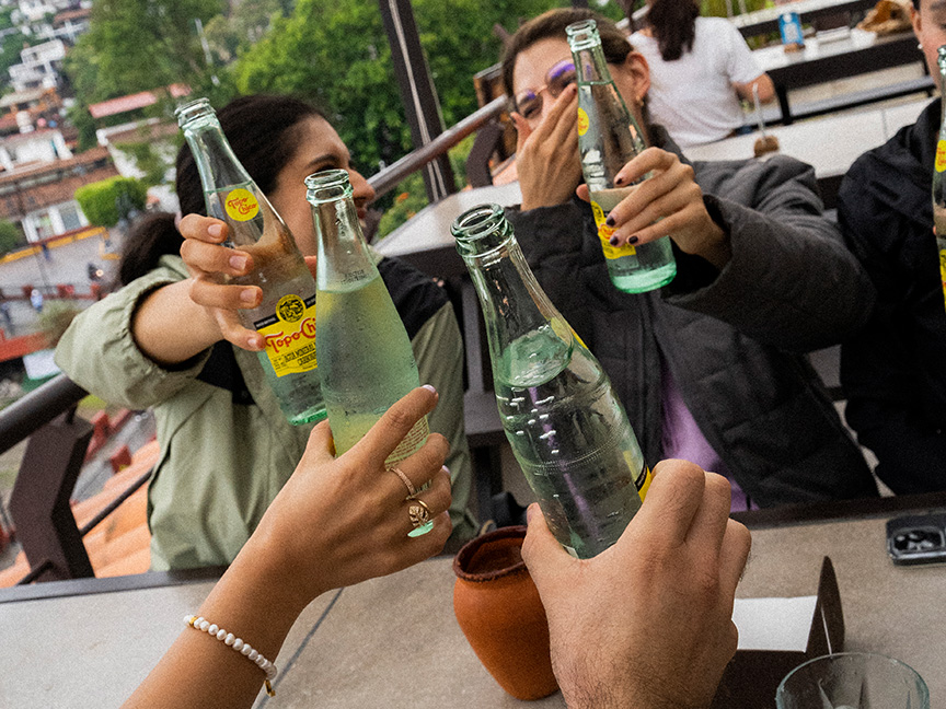 Botella de Topo Chico agua, con plato de comida y hielera Topo Chico.