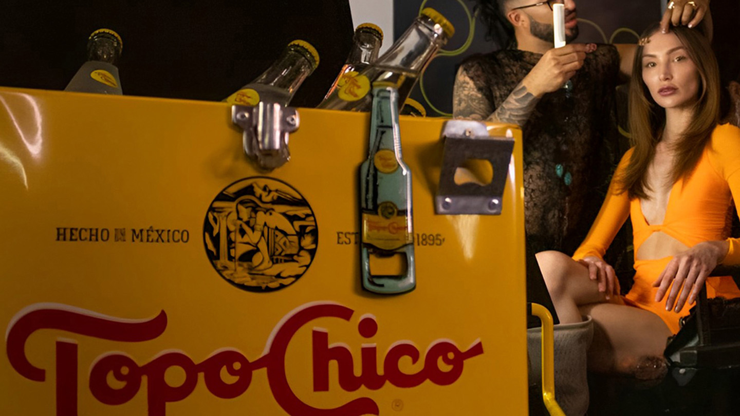 Refrigerador Topo Chico, con modelo con estilista de fondo