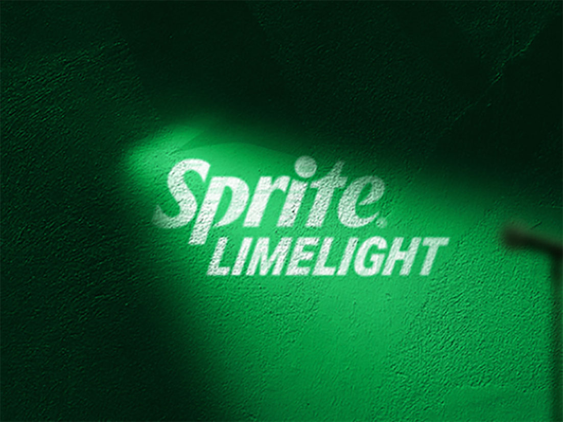 Pared verde con una luz alumbrando el centro donde se encuentra el logo de la nueva Sprite Limelight y la sombra de un micrófono sobre la pared.