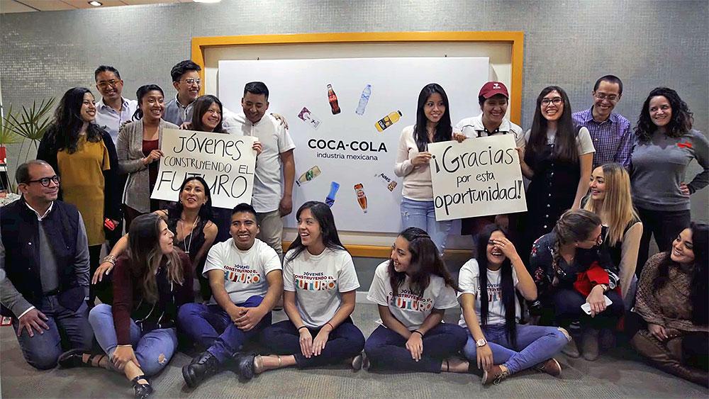 Grupo de jóvenes posan con carteles, en el Programa "Jóvenes Construyendo El Futuro"