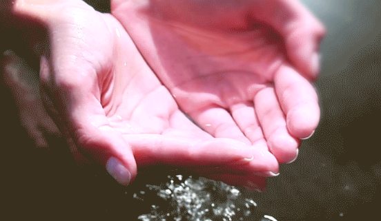 Agua fluye debajo de unas manos