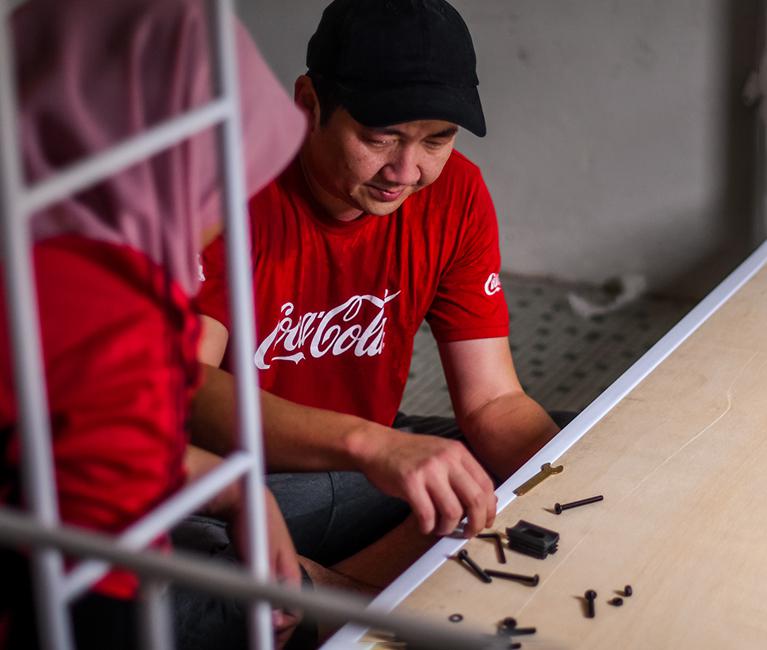 Pekerja Coca-Cola melakukan kerja kayu