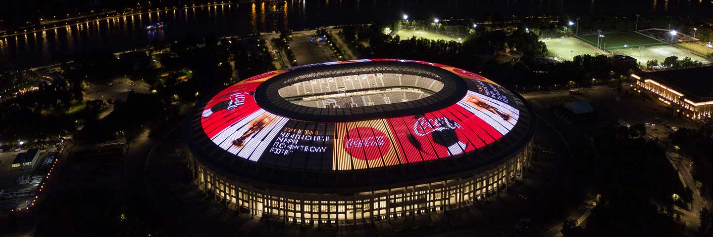 Logo Coca-Cola disinari di atas bumbung stadium padang permainan