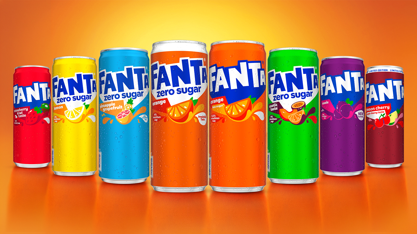 Blikjes Fanta in verschillende smaken op een oranje achtergrond.