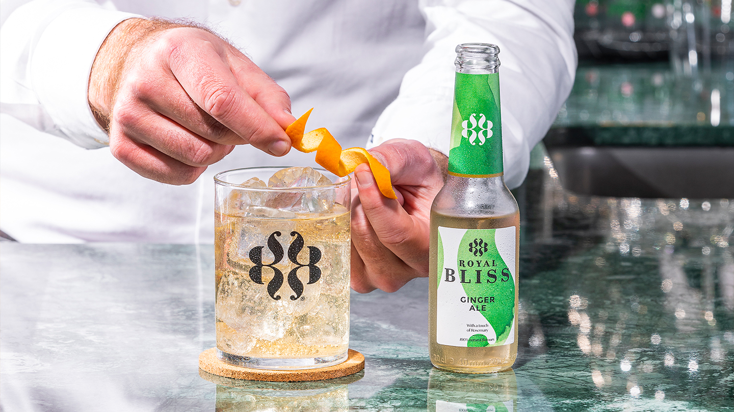 Een man giet Royal Bliss creative tonic water in het glas