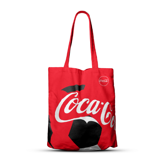 Rode stoffen draagtas met lange hengsels, voorzien van het Coca‑Cola‑logo en een grafisch voetbalontwerp, tegen een witte achtergrond.