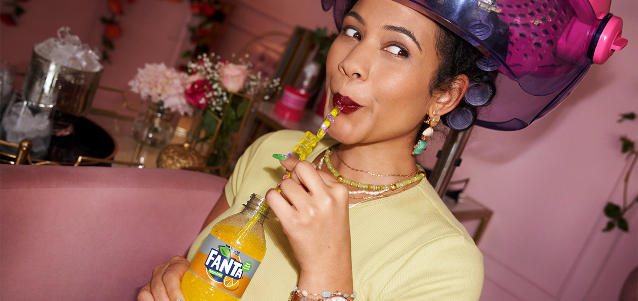 Woman laughing and drinking fanta
