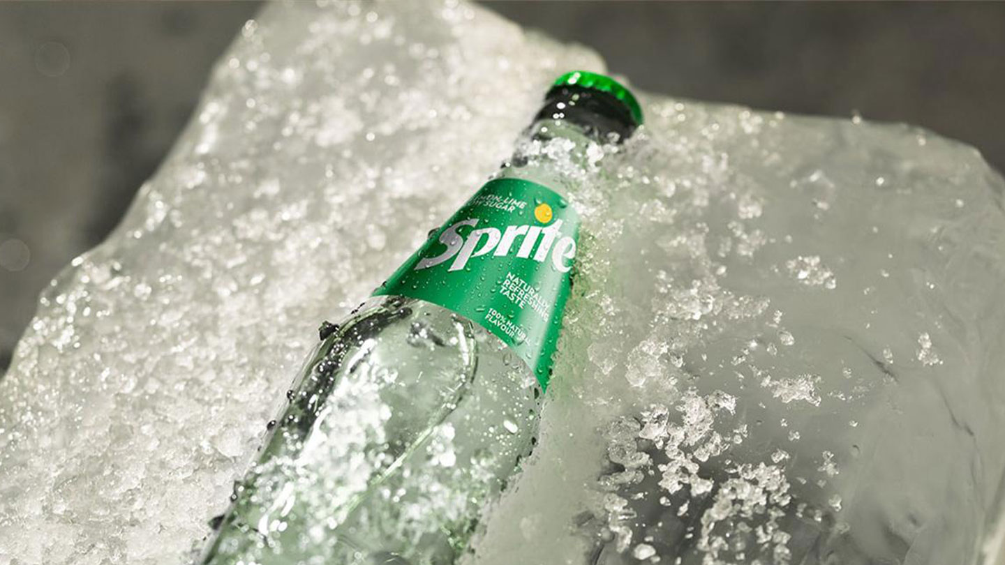 En glassflaske med Sprite som sitter fast i en stor isklump