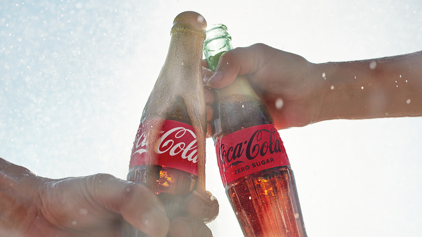 Cooler with ice full of Coca-Cola bottles in  a picnic scenario