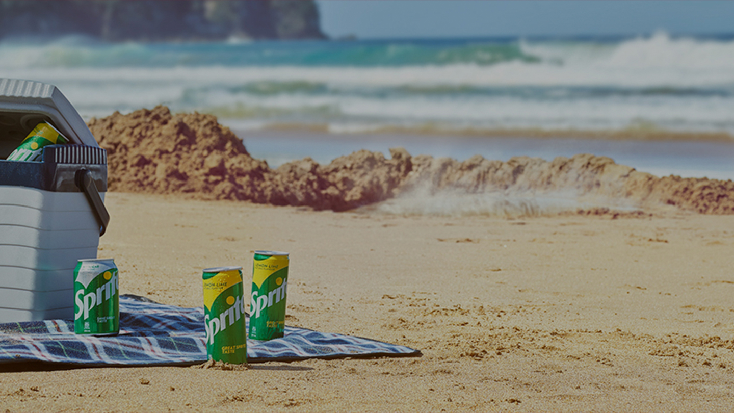 Cooler full of Sprite cans on the beachside