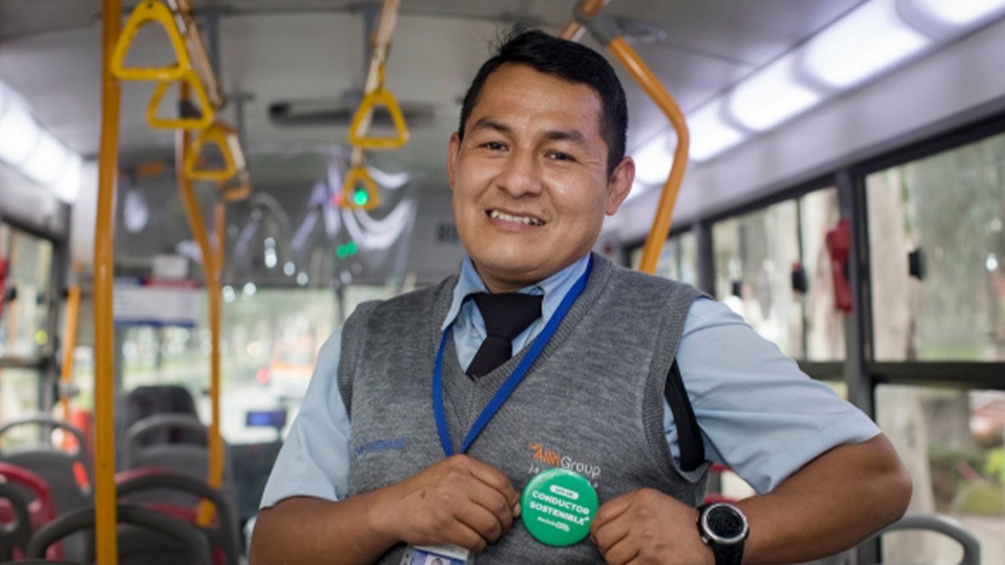 Conductor de bus sonriendo dentro de un bus.