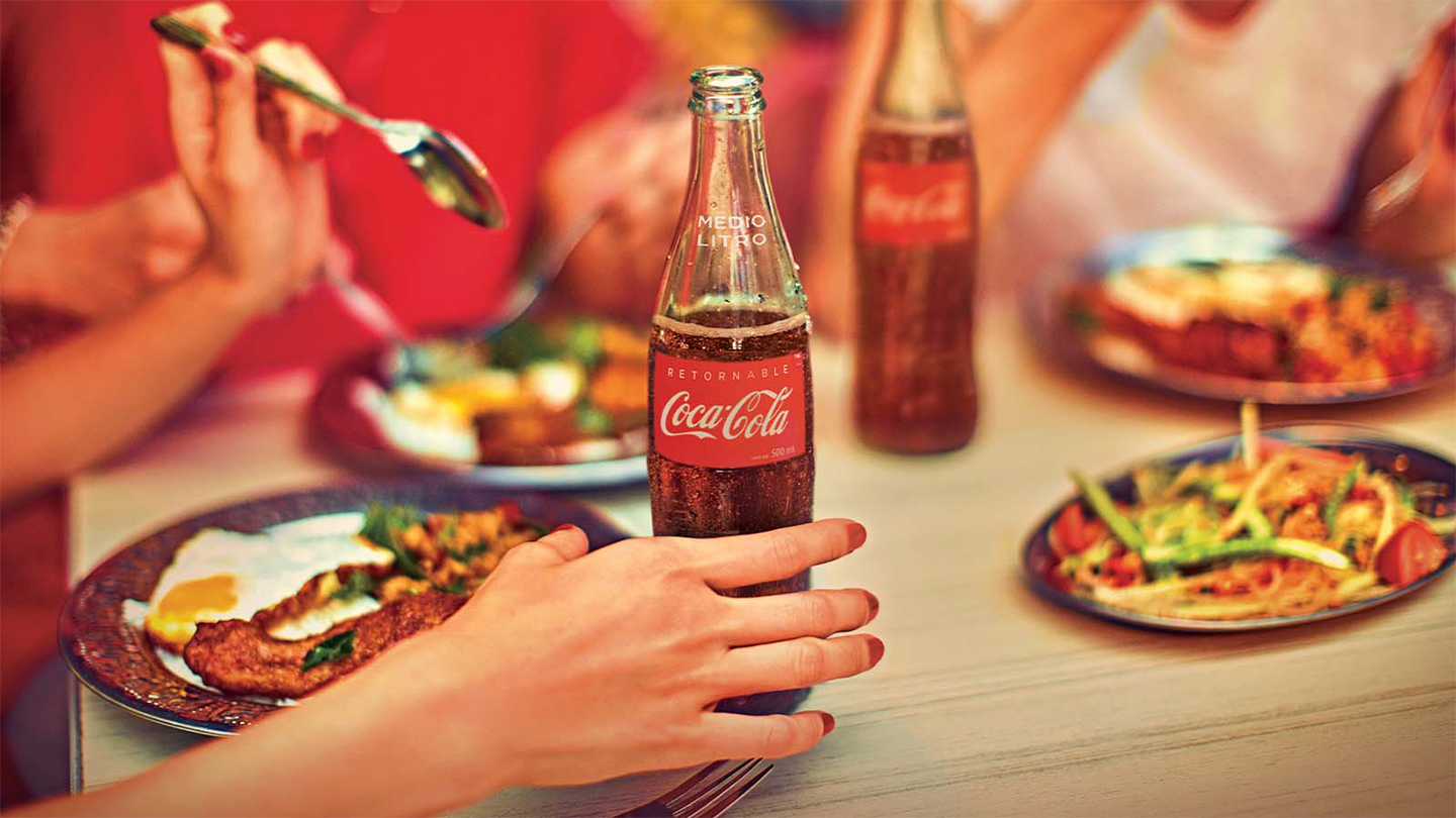 Comiendo una comida junto con la bebida de coca-cola.