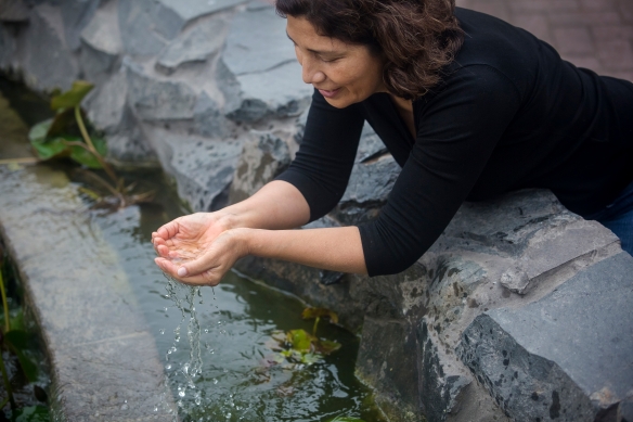 Mujer haciendo un cuenco con agua con las manos
