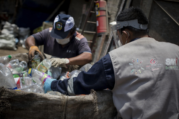 Dos trabajadores en planta de reciclaje de envases