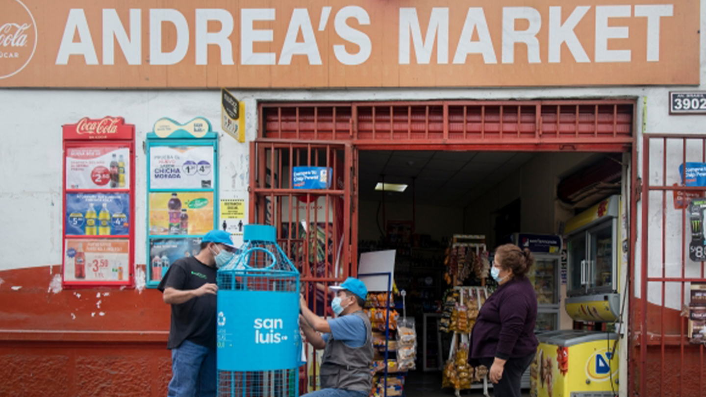 Tres personas en un minimarket instalando un punto limpio