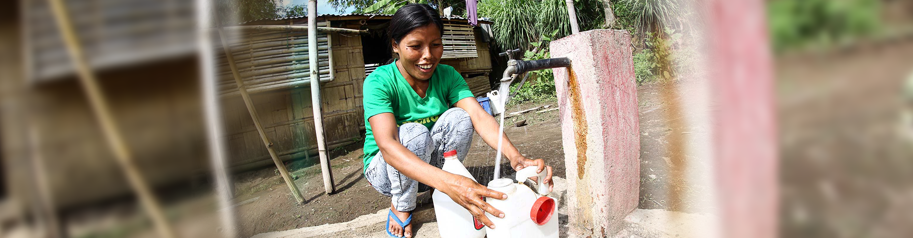 Woman filling water containers in Sumilao, Bukidnon