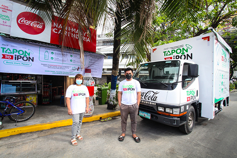 Two people with Tapon to Ipon next to a white truck