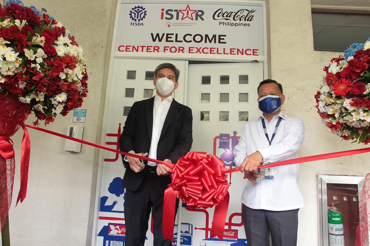 Two men standing cutting the training center opening ribbon