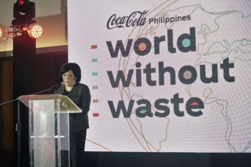 A woman speaking at a microphone during a World Without Waste conference