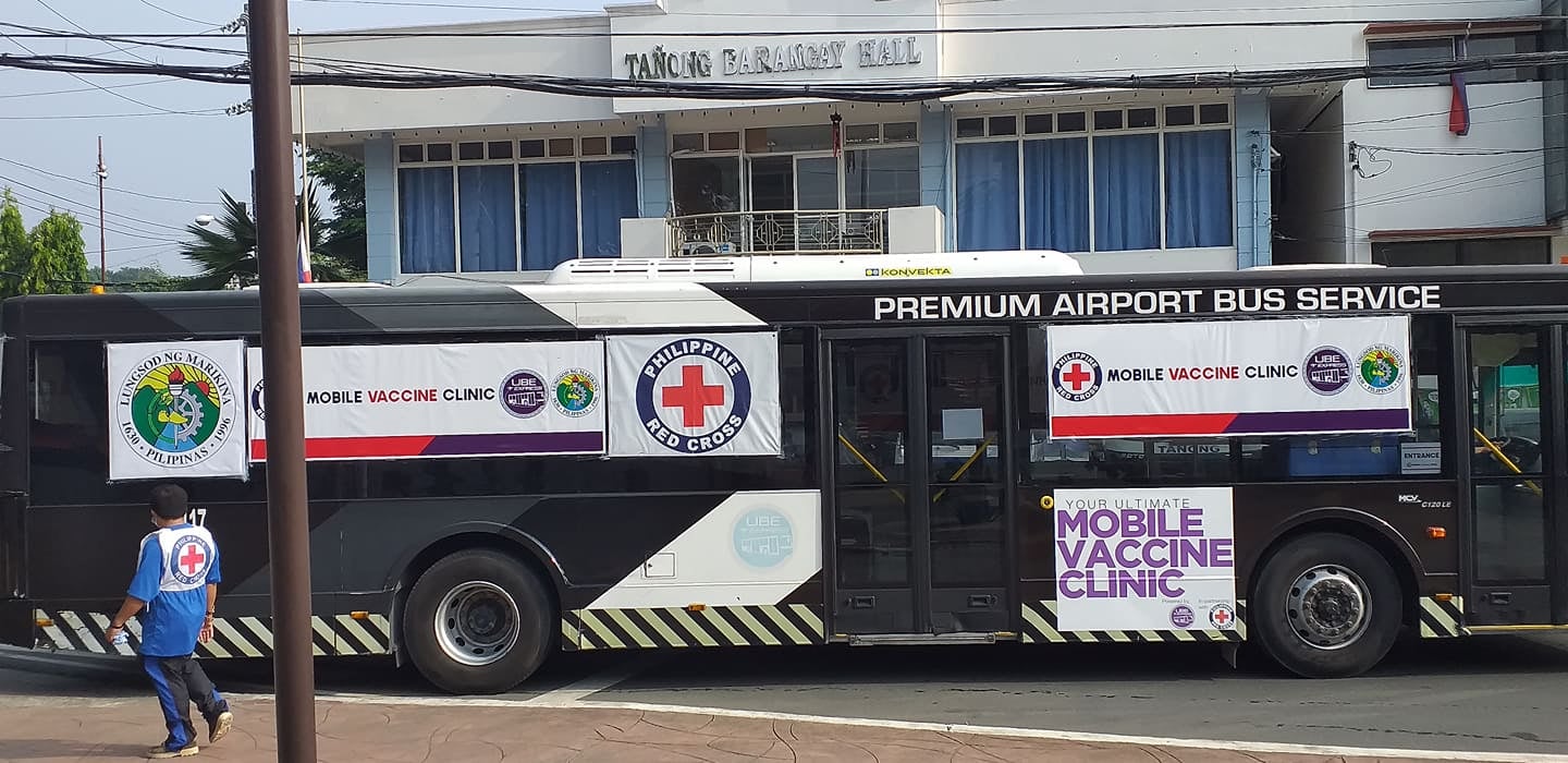 A red cross bus passing by the street